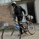 Artist Matt Hope, wearing a helmet, pushes his air filtration bike out from his studio on a hazy day in Beijing on March 26, 2013.